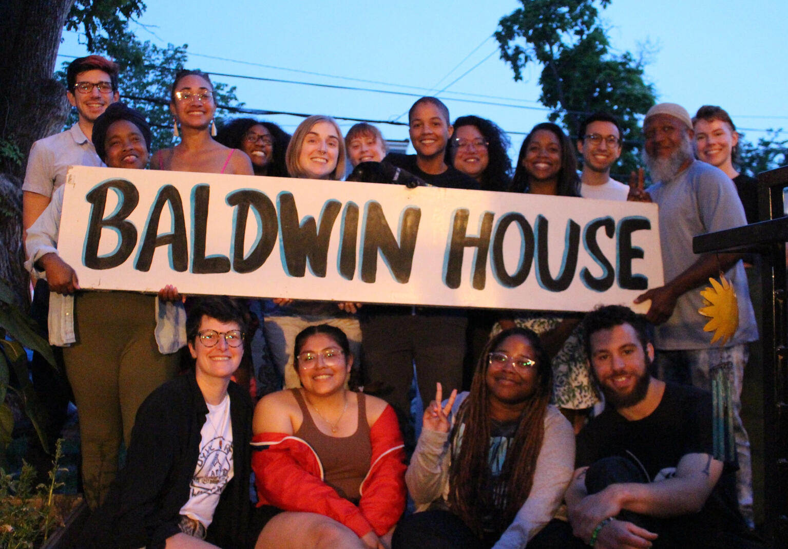 group of organizers stand around sign reading "Baldwin House"