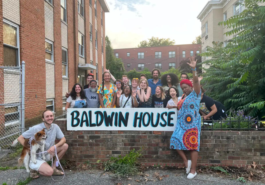 group of organizers stand around sign reading "Baldwin House" at the Baldwin House property